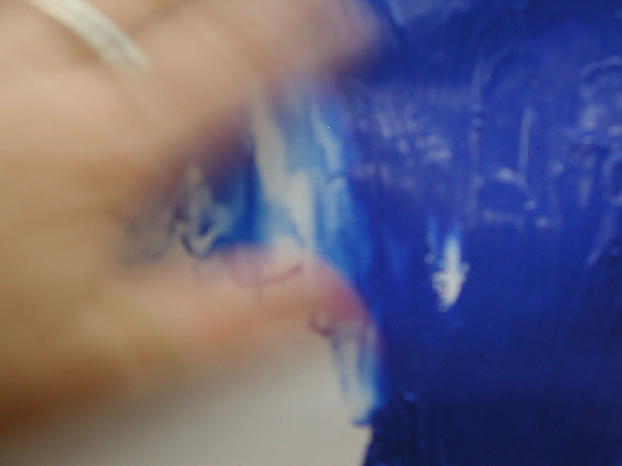 Hand malt mit blauer Farbe direkt auf Papier